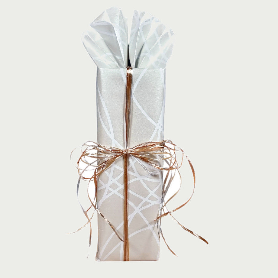 Thermosflasche in heller Geschenkverpackung mit weißen Linien und Bastschleife
